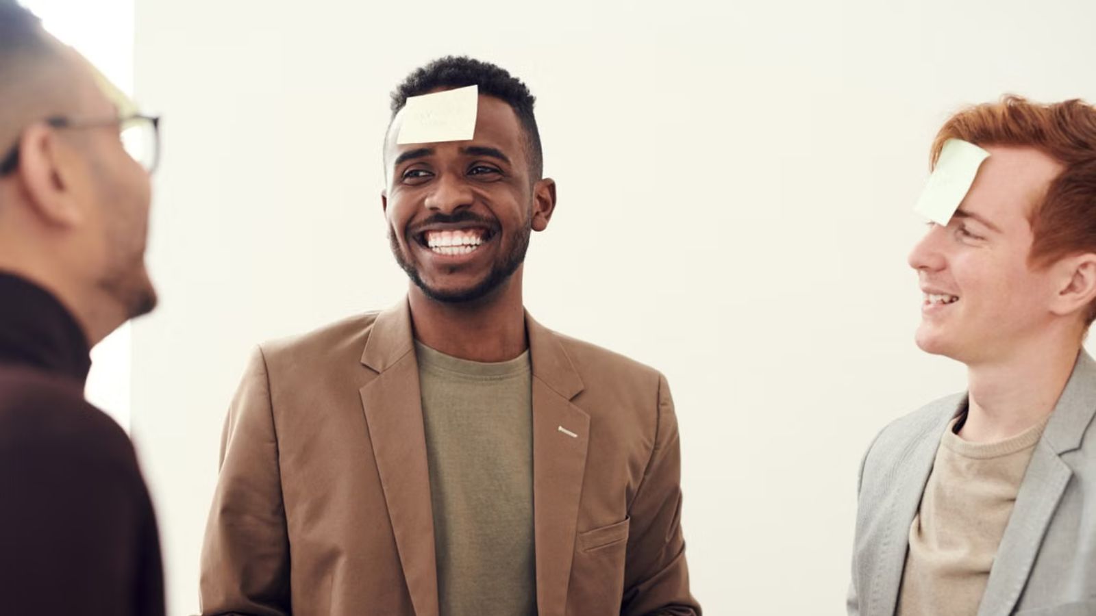 Men with Post-it notes on their forehead laughing and having a good time