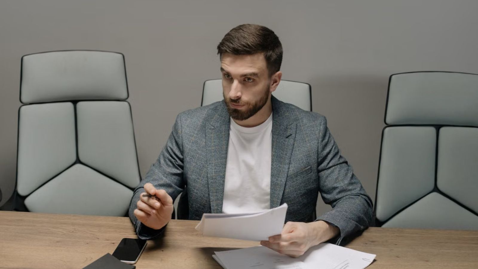 Employee in a suit holding documents during a meeting in the office 