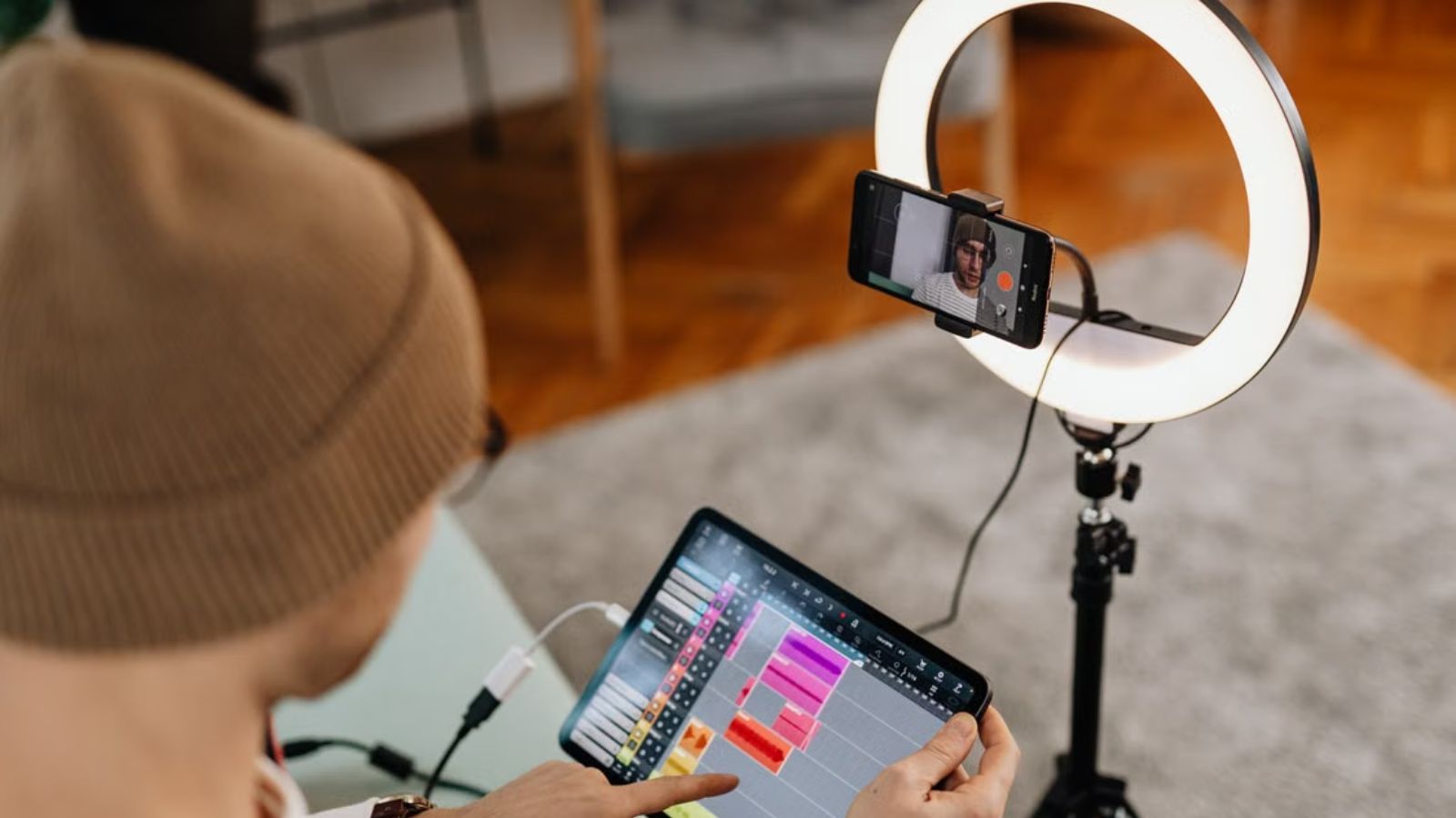 He Tried Every Job Imaginable and Hated Them All—Now He’s Considering Leaving Civilization Behind Man video recording himself in front of a ring light while editing with a tablet