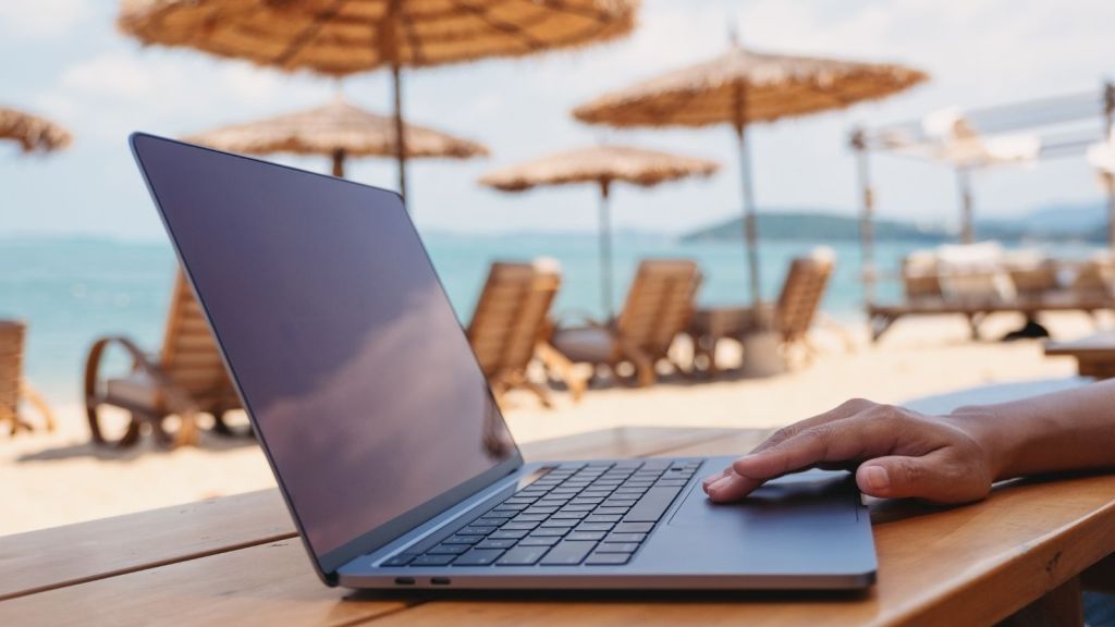 woman working remotely from the beach