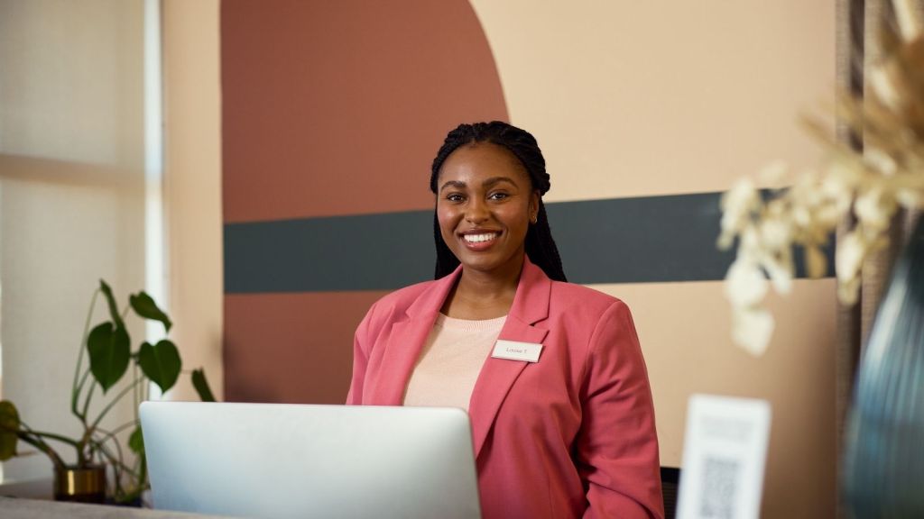 smiling woman working at a customer service desk