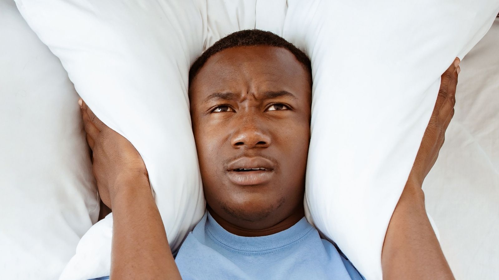 She Cant Sleep, Cant Work, and Cant Break Her Lease: The Nightmare of Living Next to Unchecked Noise Violators man having trouble sleeping because of noise