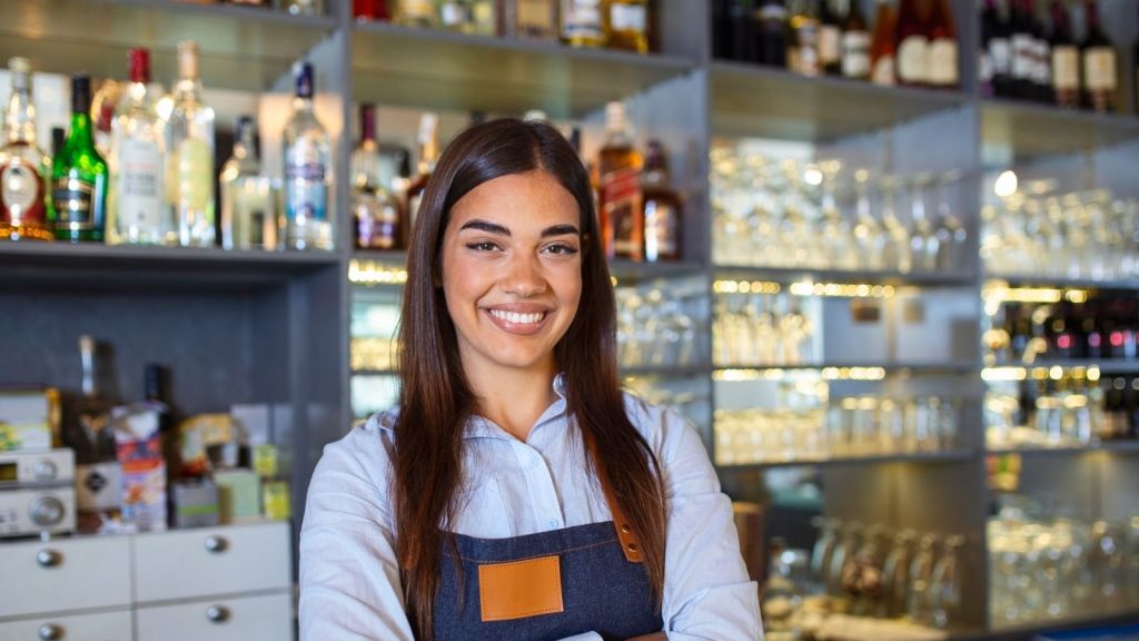 smiling woman working at a bar