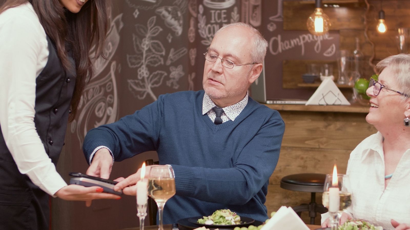 older man paying bill at restaurant