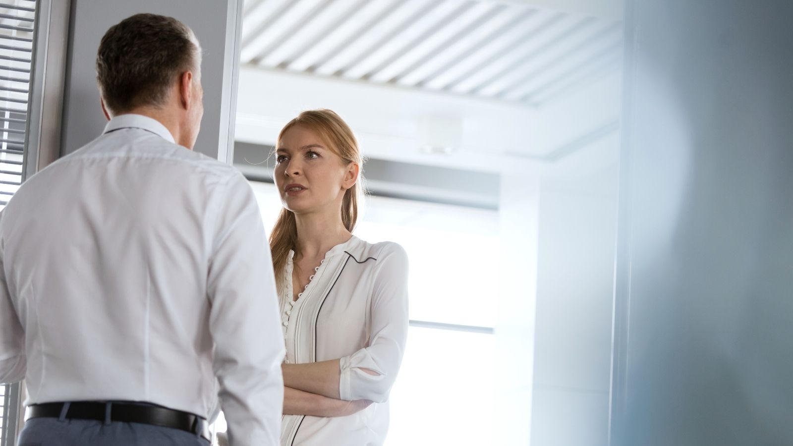 Woman Says Male Coworkers Crossed a Line by Commenting on Her Weight, So She Reported Them woman looking unhappy at what a male coworker is saying