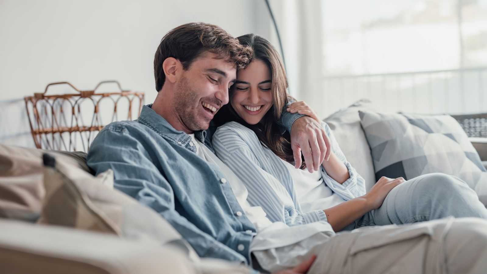 happy young couple sitting on the couch together