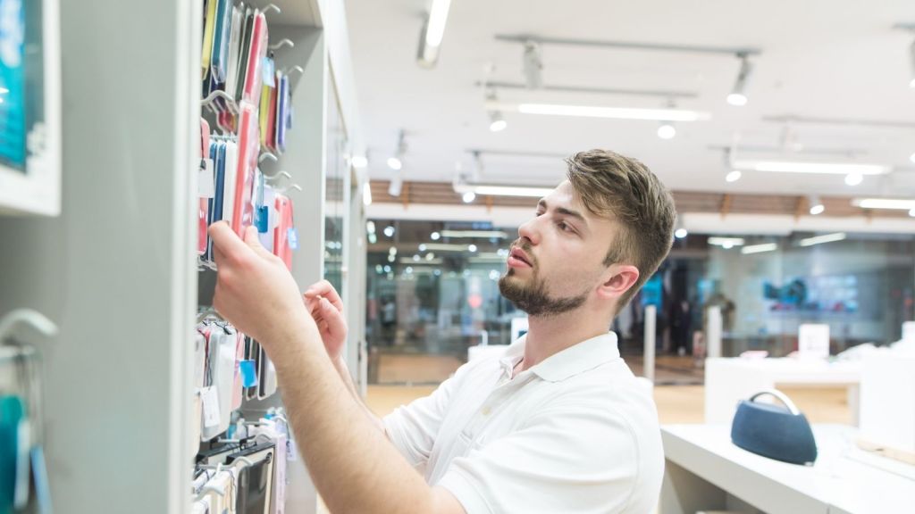 man looking at phone accessories in a store