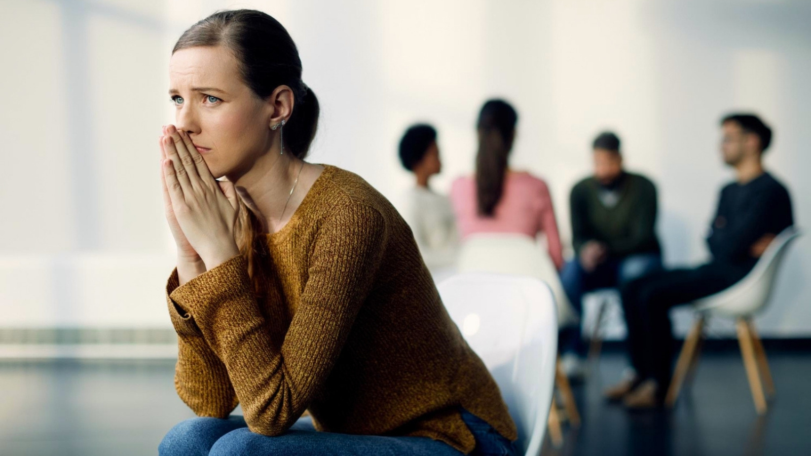 She Had Four Strong Months on the Job—Until Corporate Told Her Being an Introvert Was Something She Needed to Fix. Woman sitting separately from group