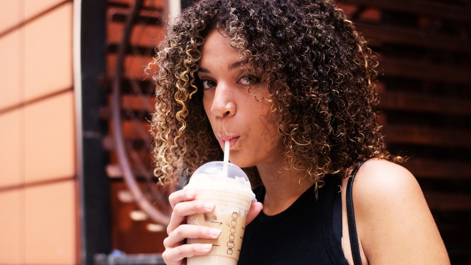 Woman drinking iced coffee outside
