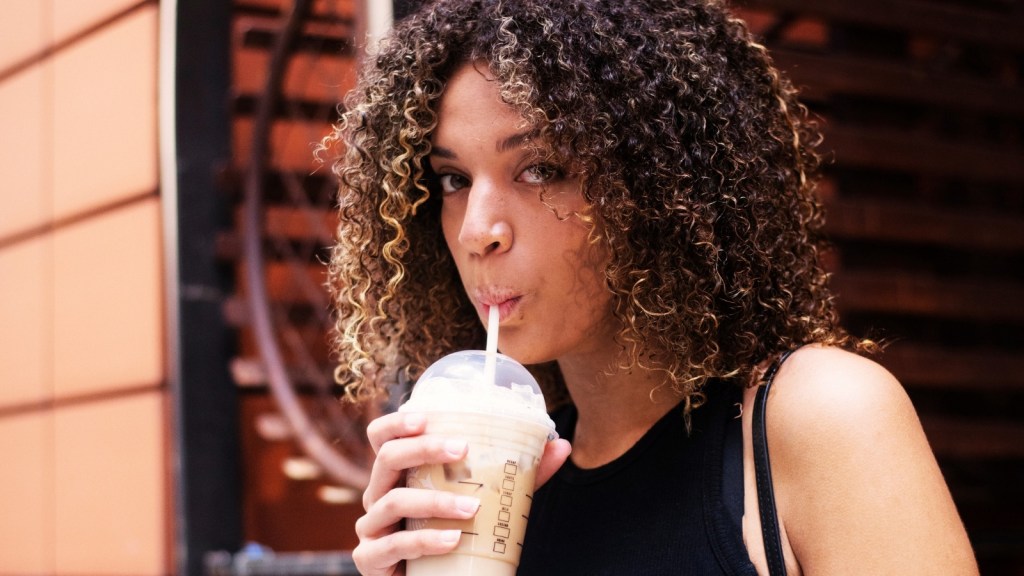 Woman drinking iced coffee outside