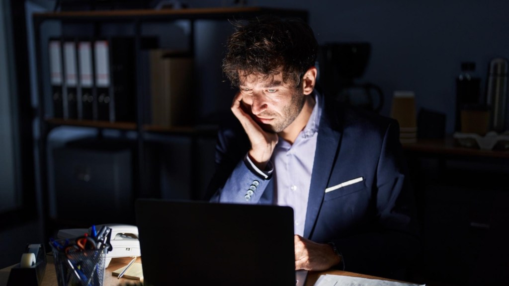 Tired man looking at his laptop