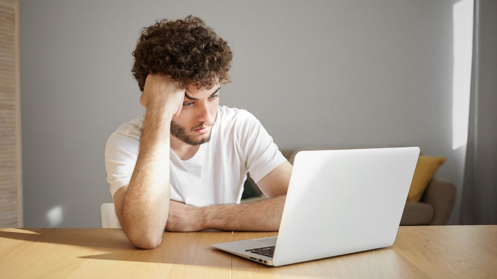He Waited Over a Year for a Full Time Spot. His Boss Handed It to a New Hire on Day One. Upset looking man using a laptop