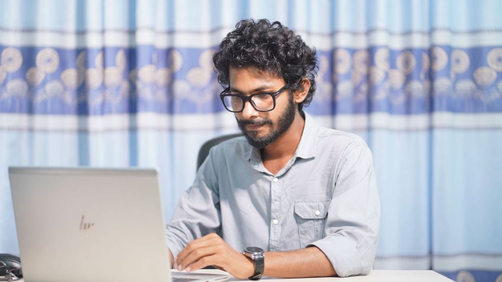 Man in glasses working on laptop