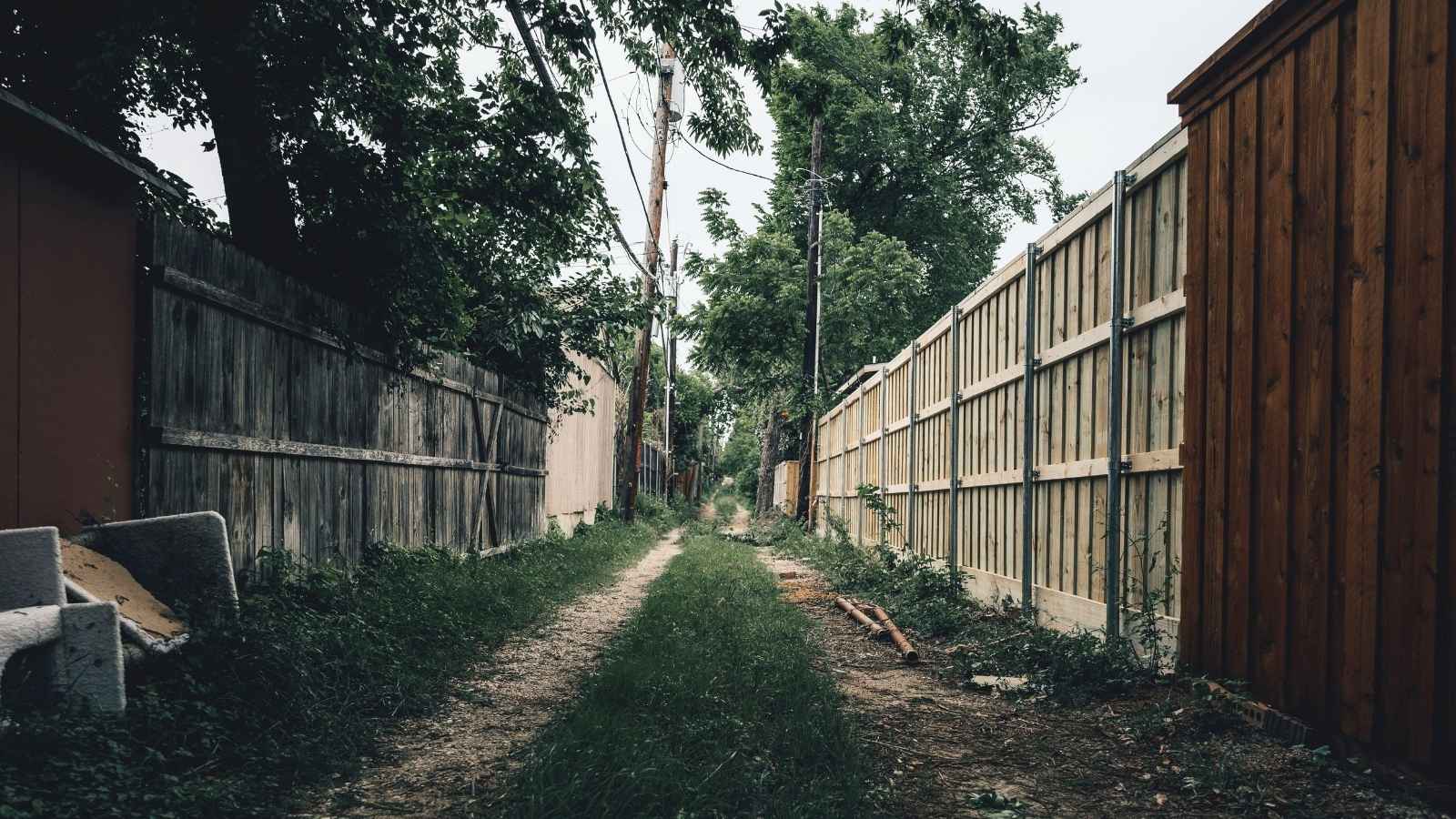 The Deed Trap: Why an Outraged Homeowner Refused to Sign Away Their Yard After a Neighbor’s Structure Crossed the Line an alley with two neighboring fences