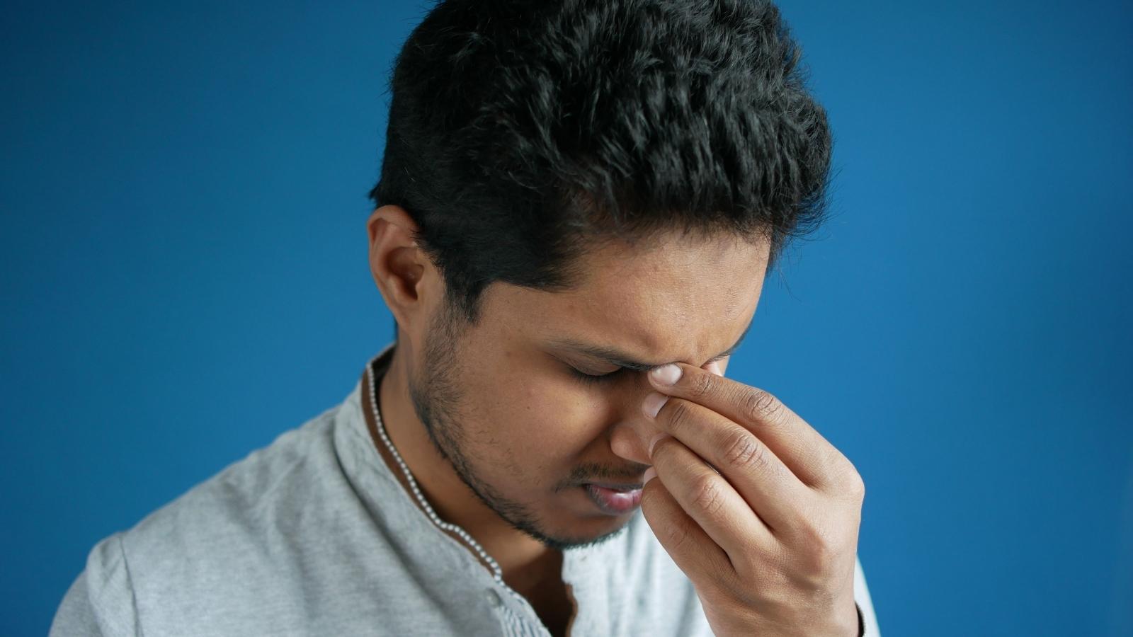 annoyed man holding his nose