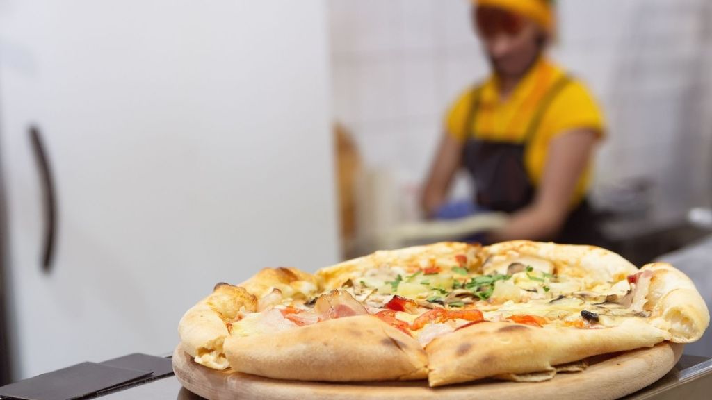 person working in a pizza shop