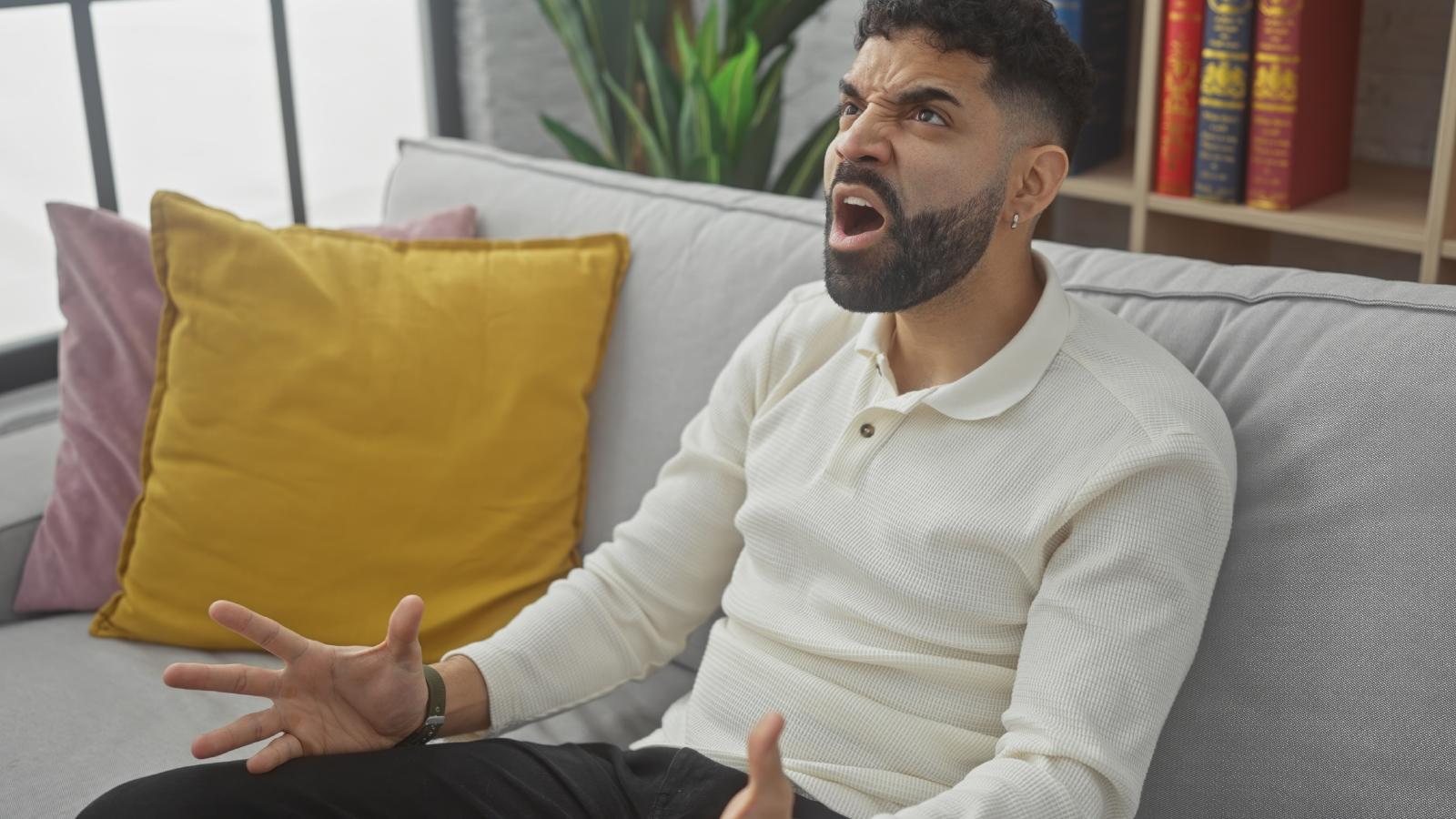 Man Says Constant Complaints From Downstairs Neighbor Are Making It Hard to Enjoy His Home man on his couch