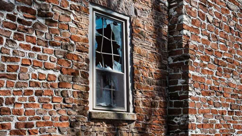 closeup of broken window on brick house