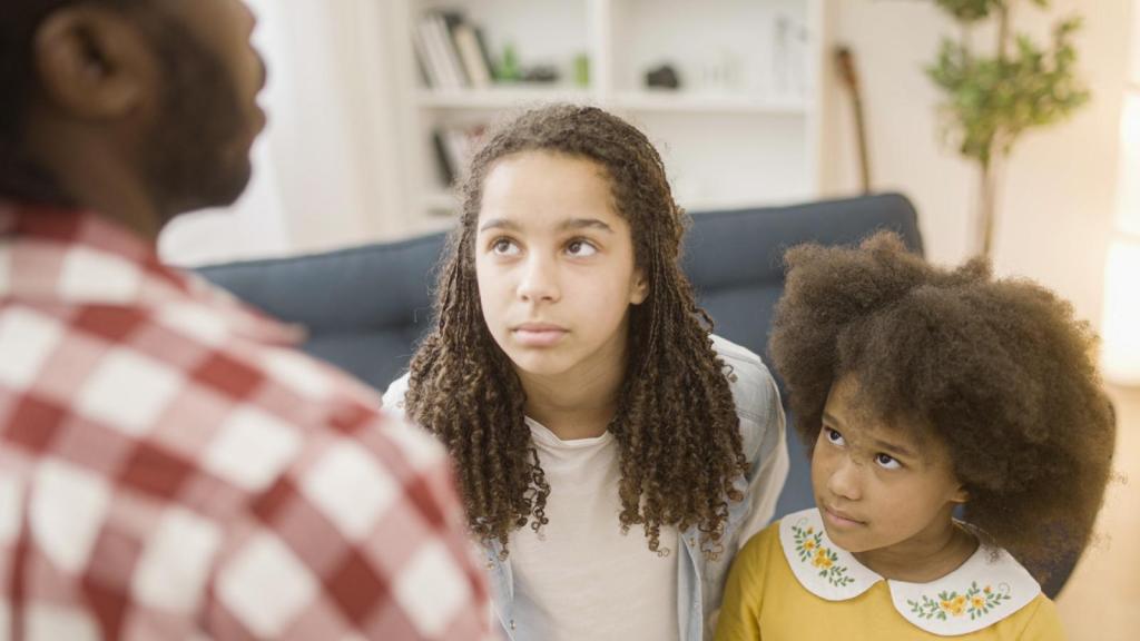 man talking to his daughters
