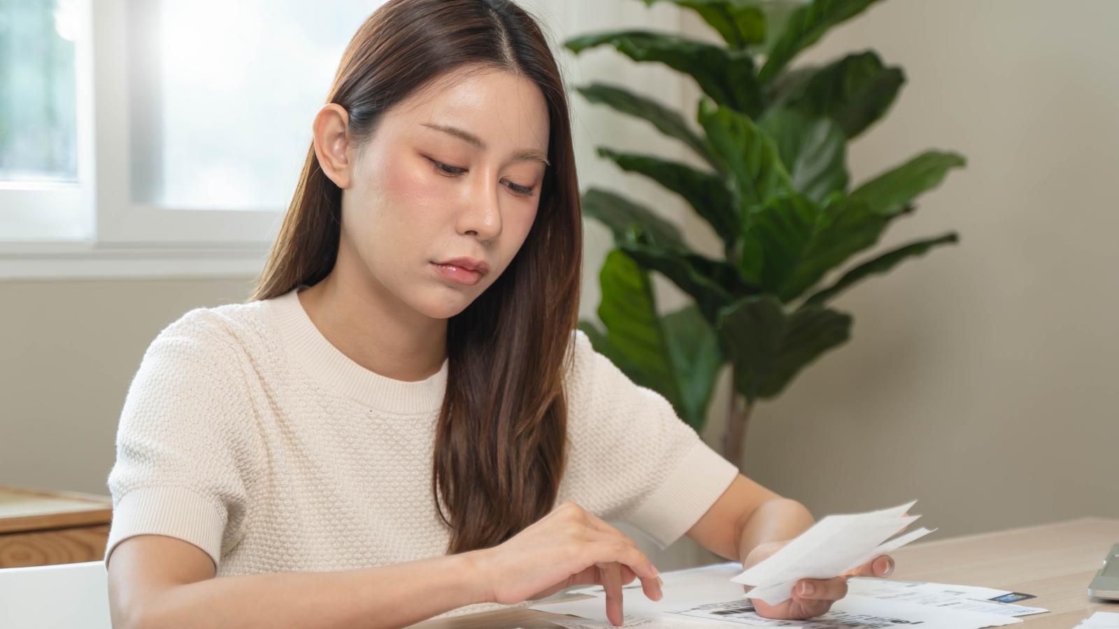 For Just One Person?: Renter’s Shocking First Water Bill Triggers Search for Hidden Apartment Secret woman looking at some bills