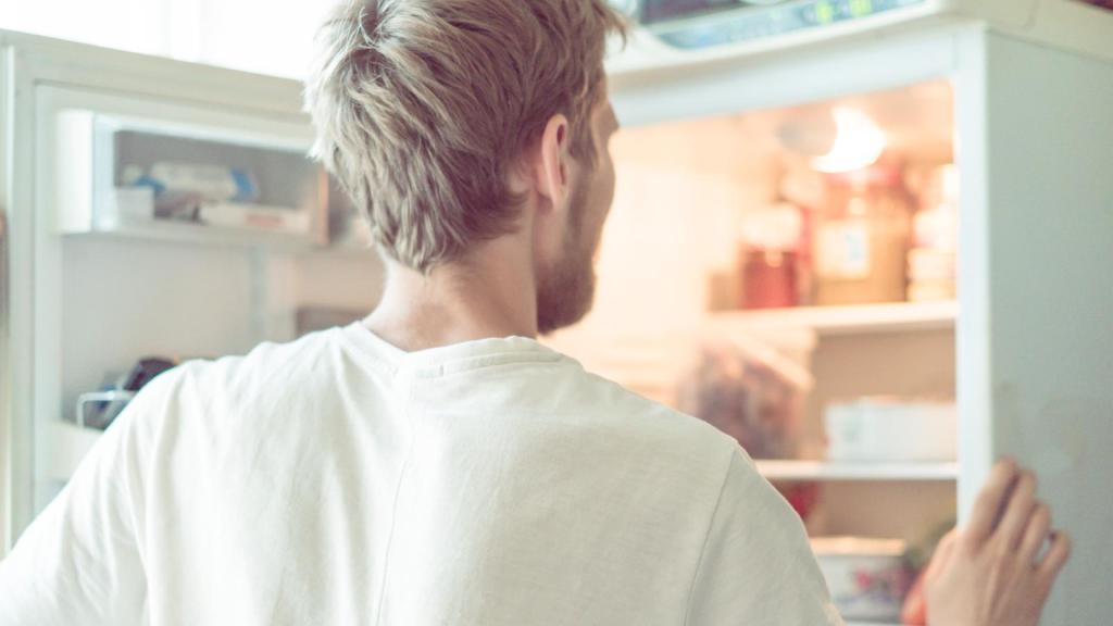 man looking in a refrigerator