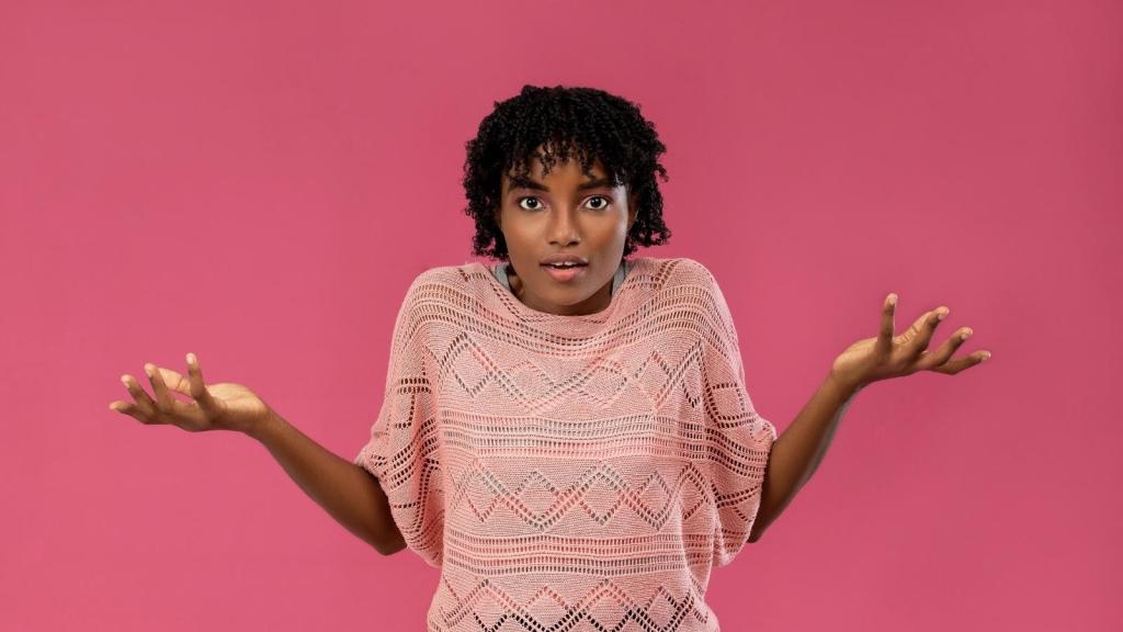 confused woman in pink shirt shrugging