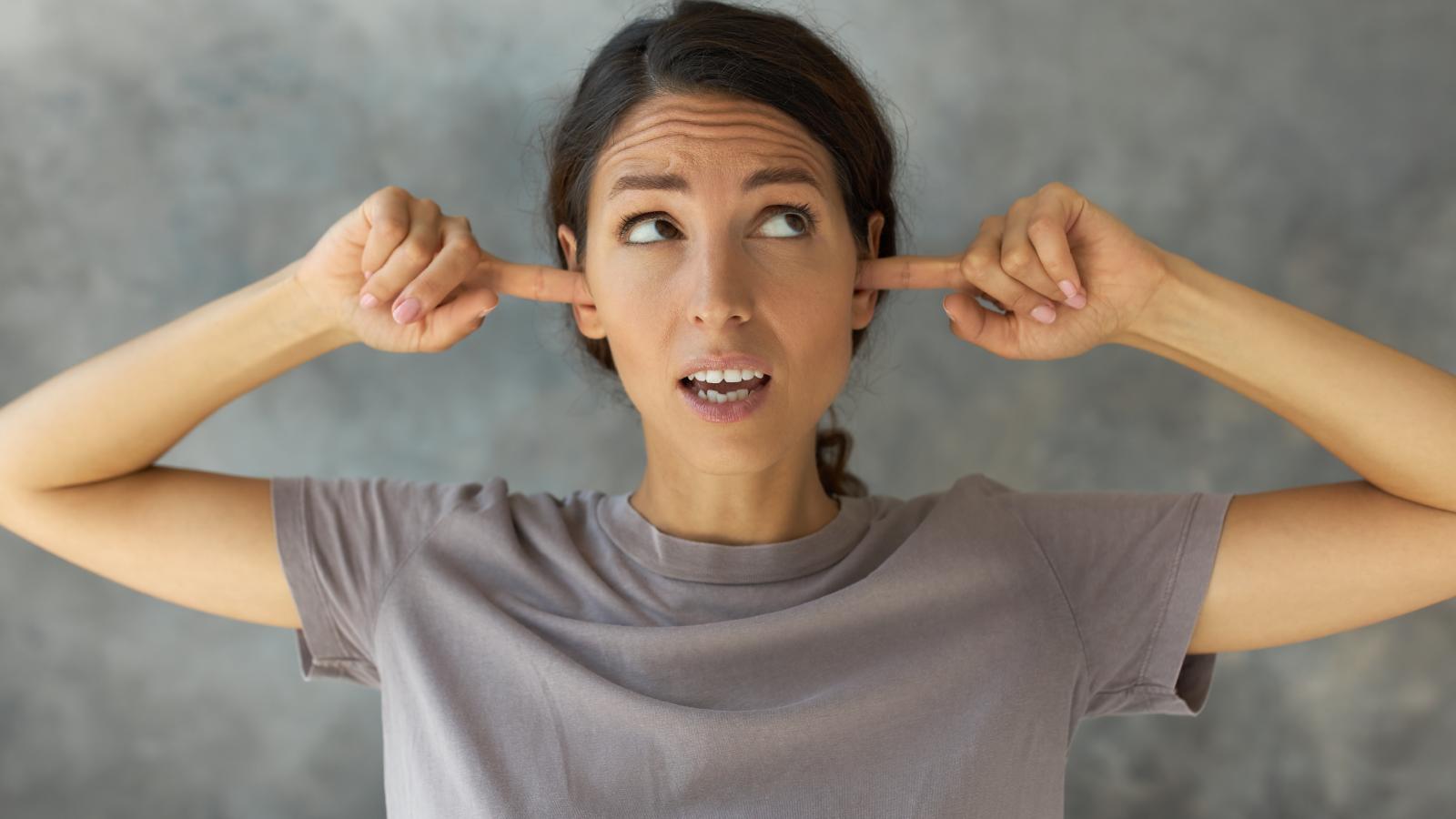 Pregnant Womans Neighbors Make Too Much Noise When Shes Trying To Sleep, So She Desperately Wants The Noise To Stop woman plugging her ears