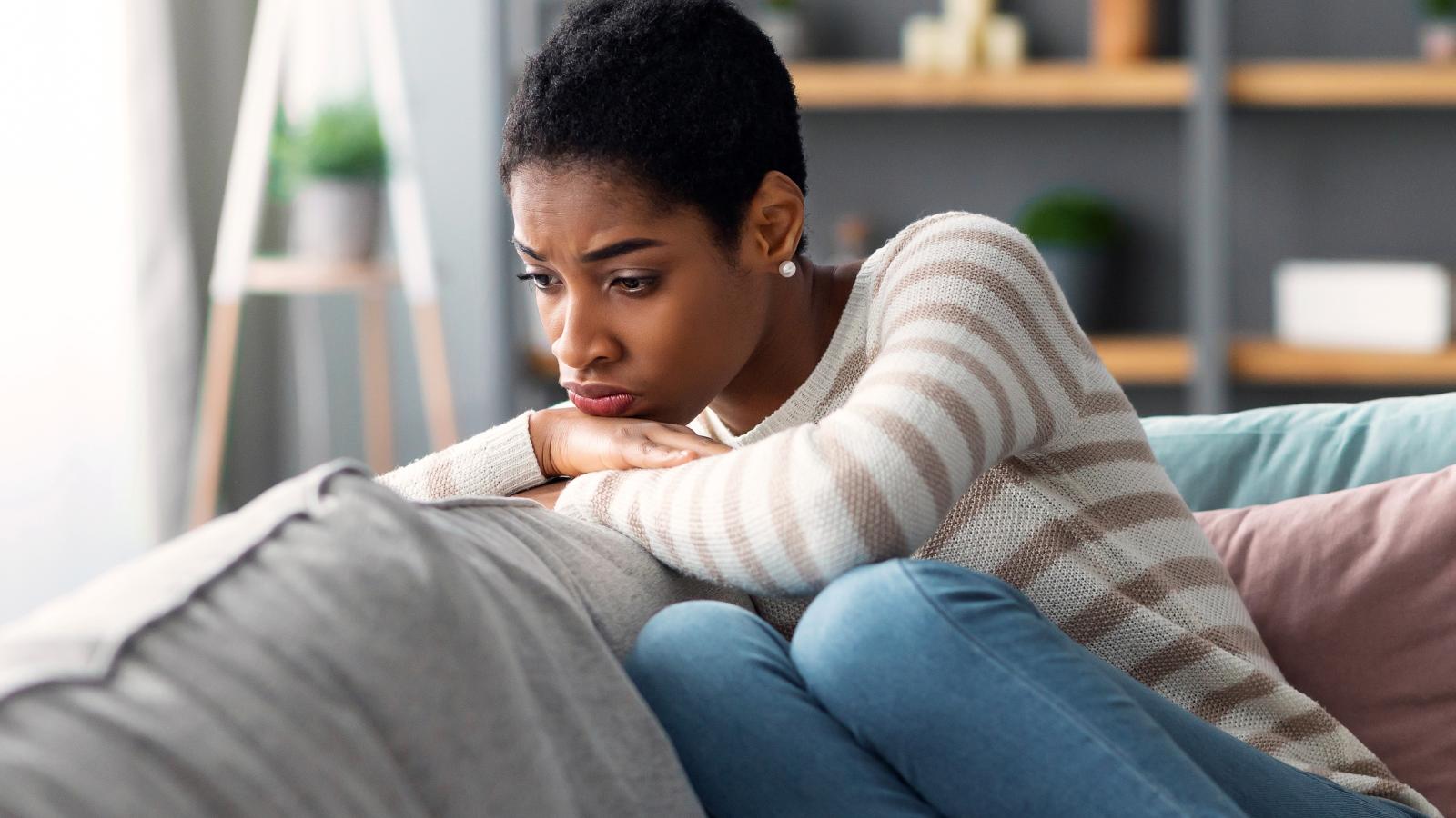 She Started Banging on the Ceiling Over Minor Sounds—So Her Upstairs Neighbor Considered Calling Management woman on a couch