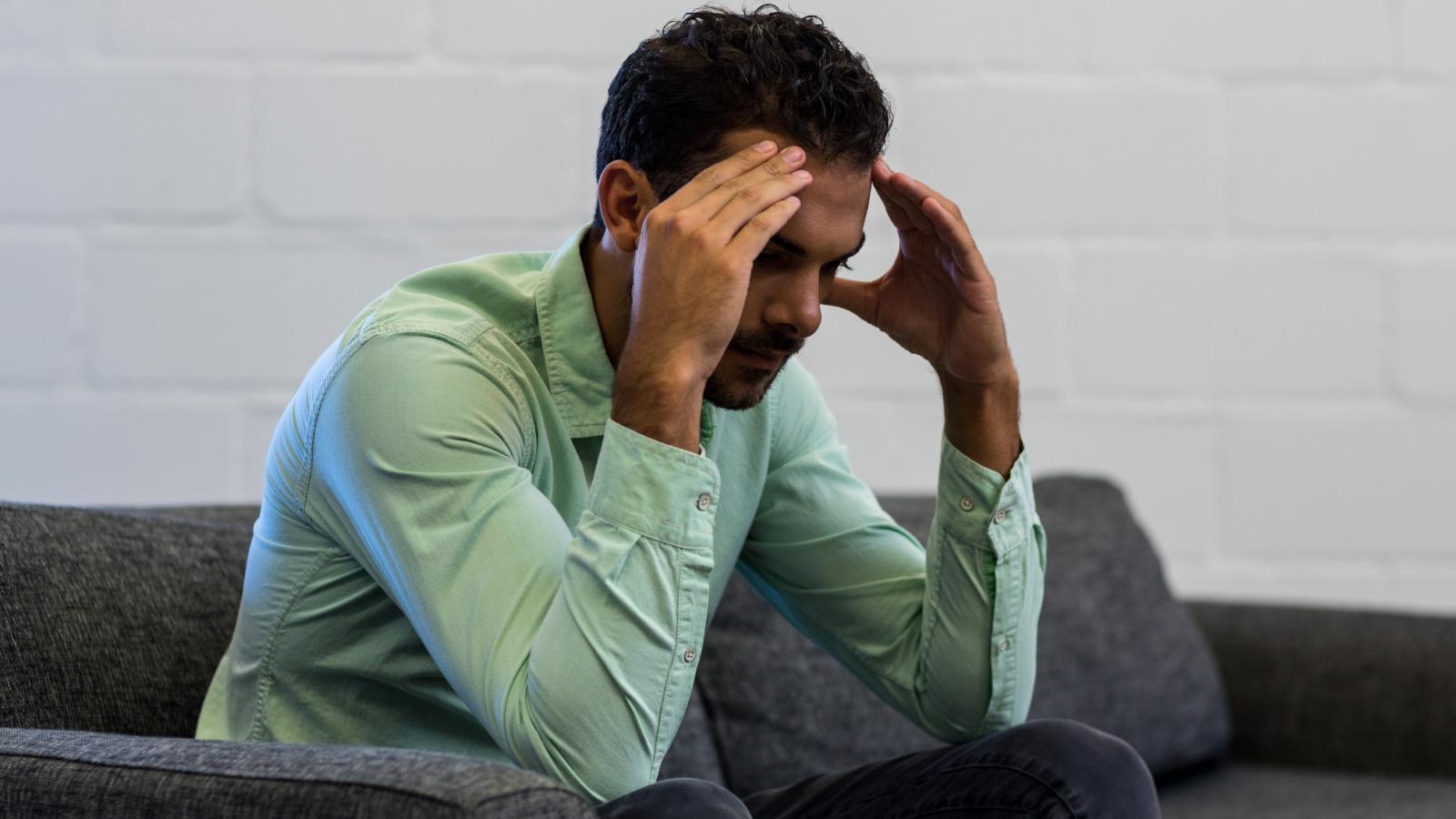 Crowded Apartment and Unpredictable Roommates Push Man to His Breaking Point man with his head in his hands