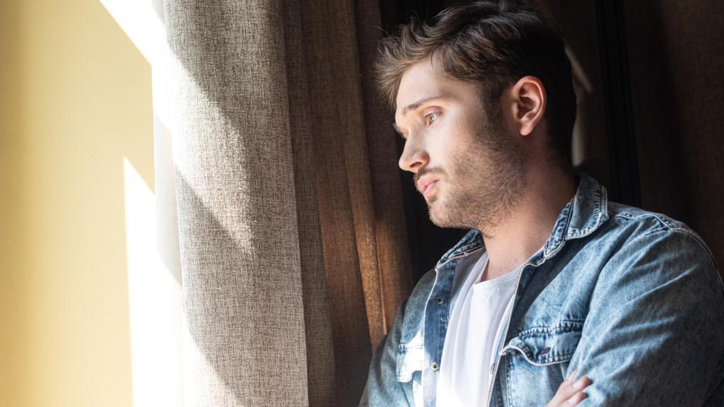 man looking out a window