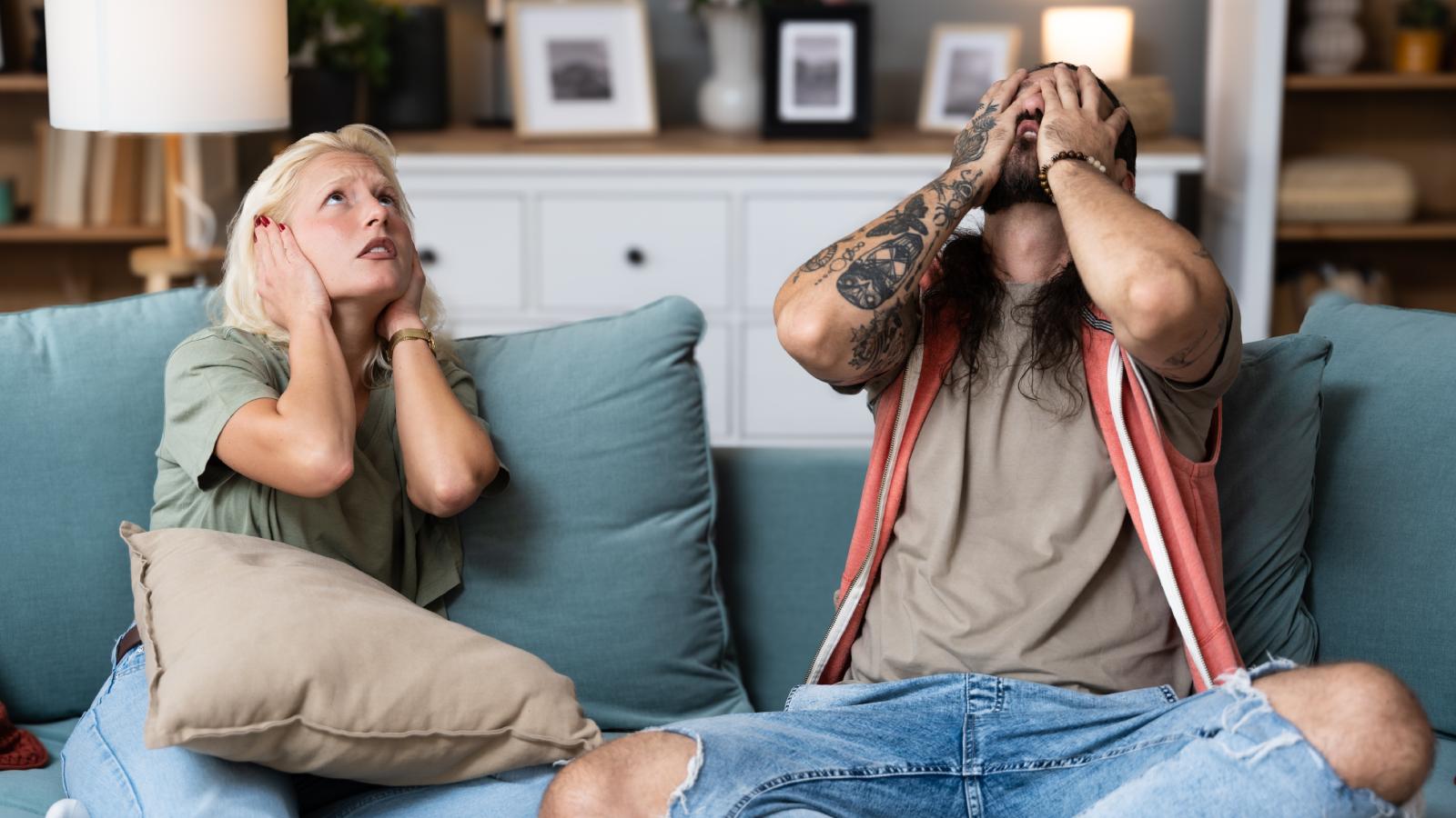 His Upstairs Neighbors Turned Their Apartment Into an Unofficial Airbnb—Now the Non Stop Noise Is Ruining His Life couple looking at their ceiling