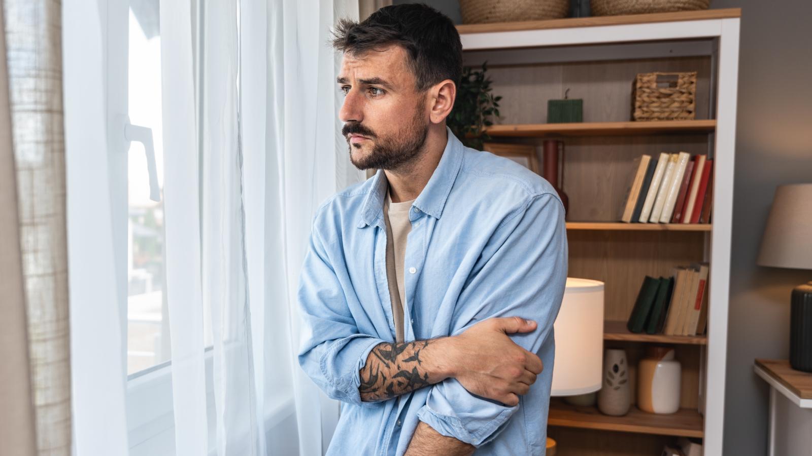 New Homeowner Caught in Awkward Feud After Neighbor Loses Chance to Buy the House man looking out a window