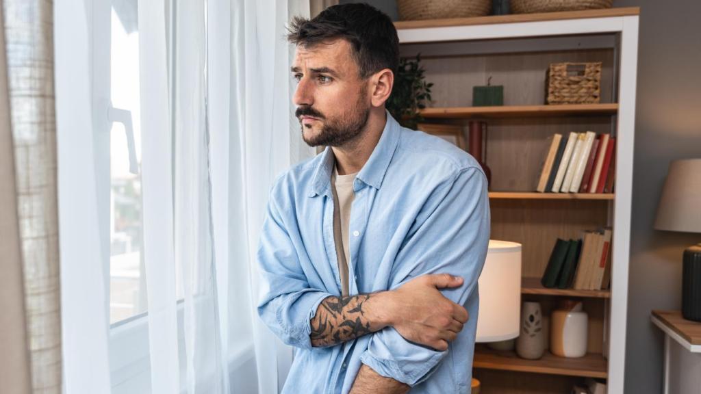 man looking out a window
