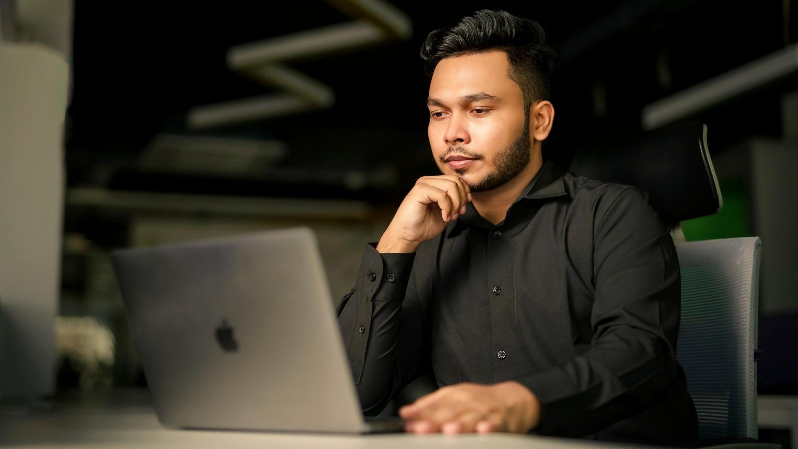 corporate employee looking at his laptop
