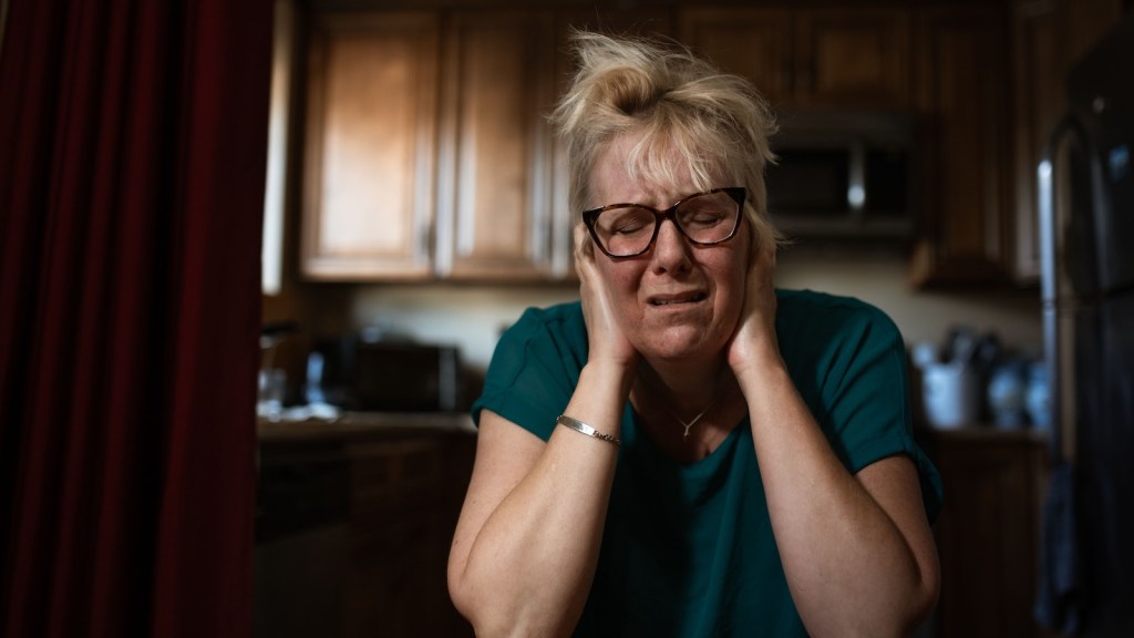 woman covering her ears because of loud noises