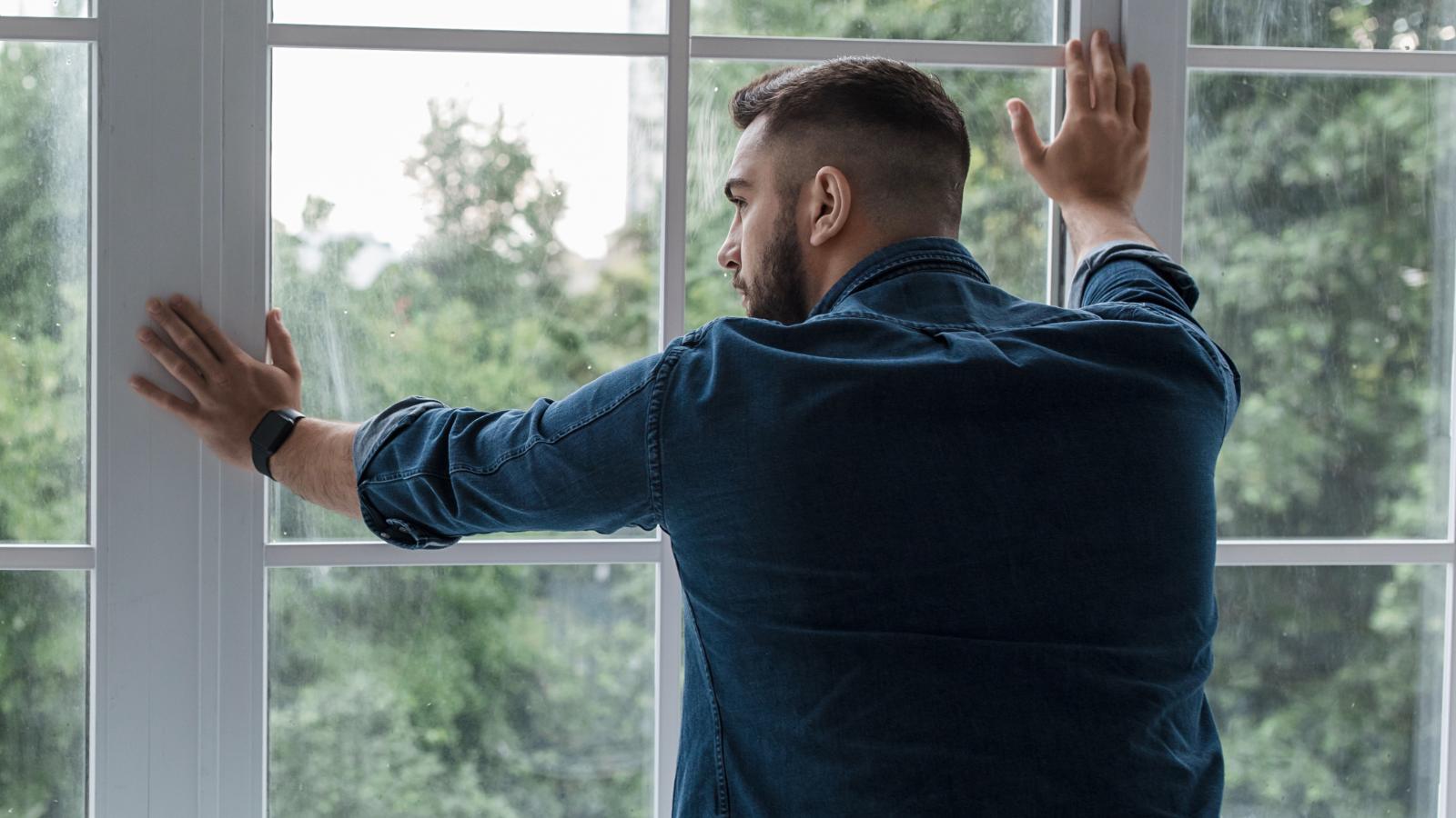 An Assisted Living Neighbor Keeps Yelling Hurtful Things—Now Someone Is Unsure What to Do man looking out a window