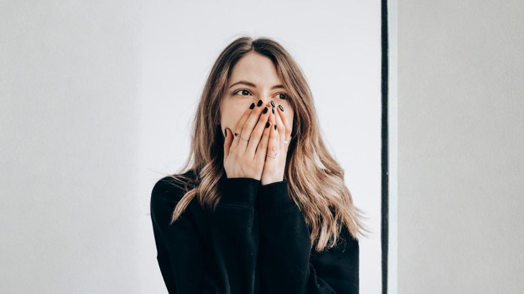 embarrassed woman covering her mouth