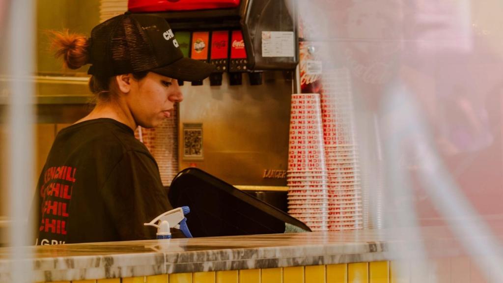 fast food worker by soda machine