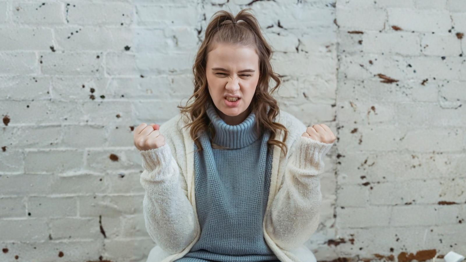 frustrated young woman in blue turtleneck