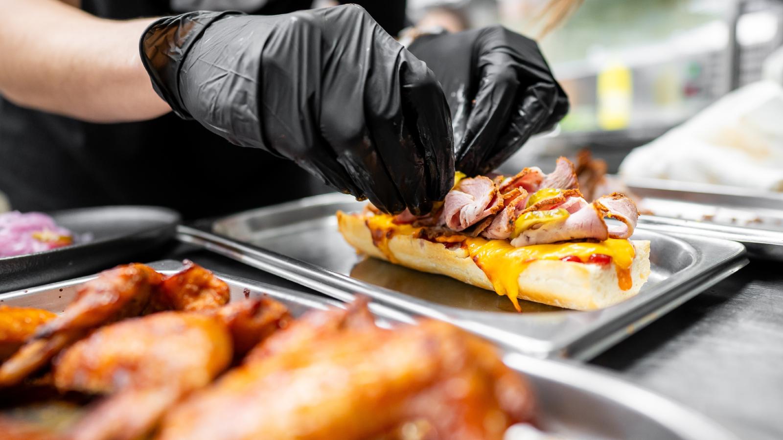 Her Restaurant Manager Keeps Reusing the Same Gloves While Handling Food to Save Money — Shes Fed Up and Speaking Up person making a sandwich