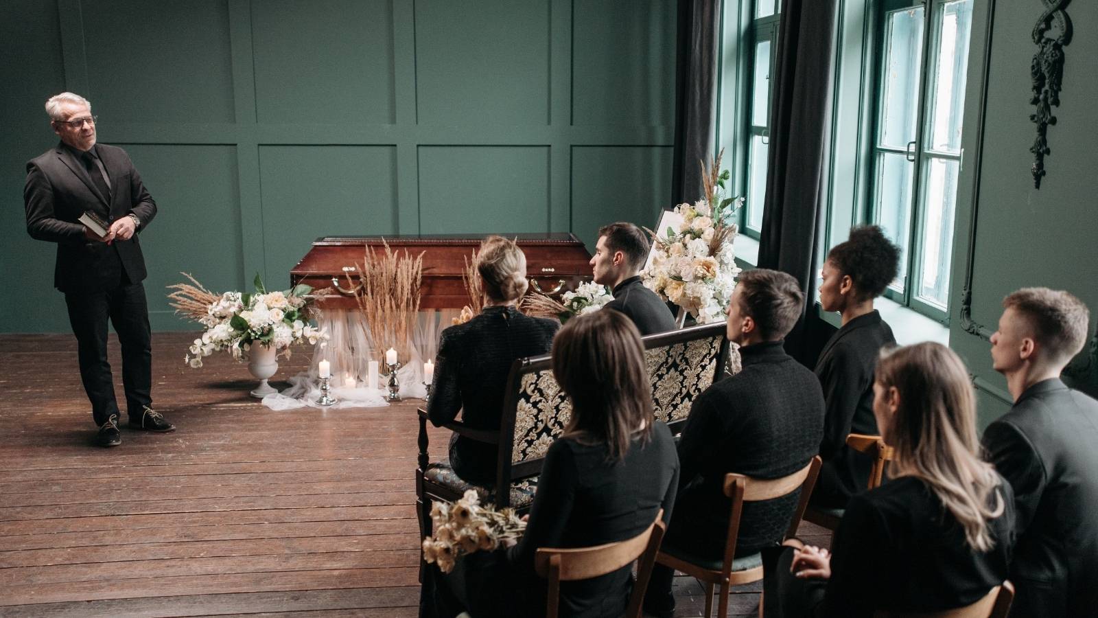 His Family Is Splitting His Fathers Funeral Costs at $5,000 Per Person — Hes Noticed Not Everyone Can Equally Afford That group of people sitting at funeral service