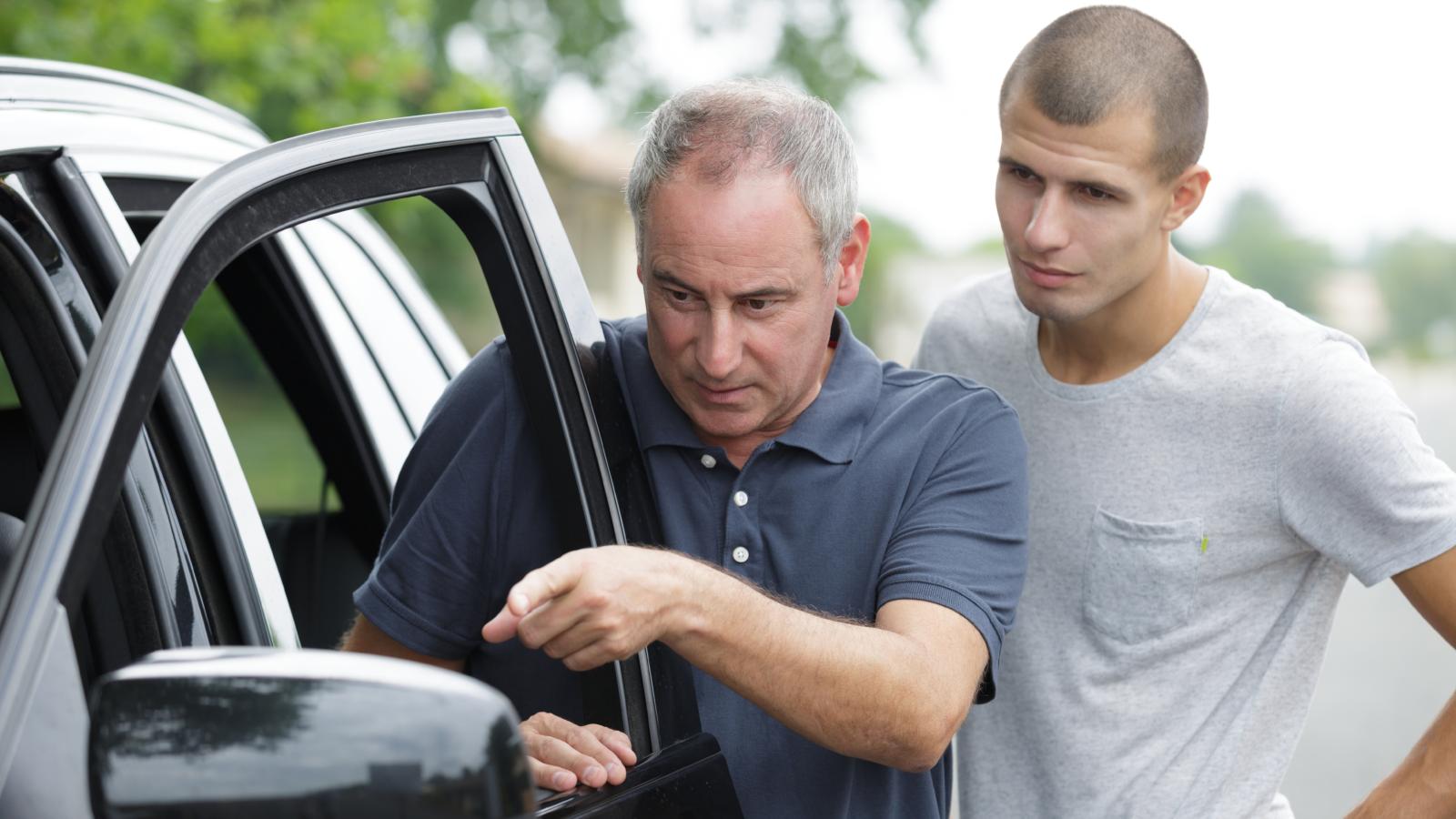 two men outside of a car
