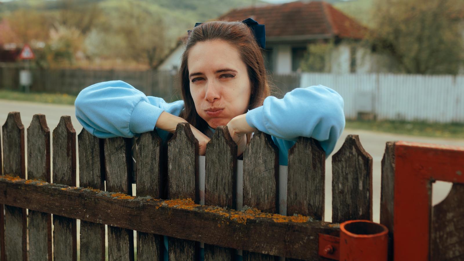 Neighbor Wont Stop Messing With Her Lawn—Now Shes Considering Calling The Police woman leaning on a fence