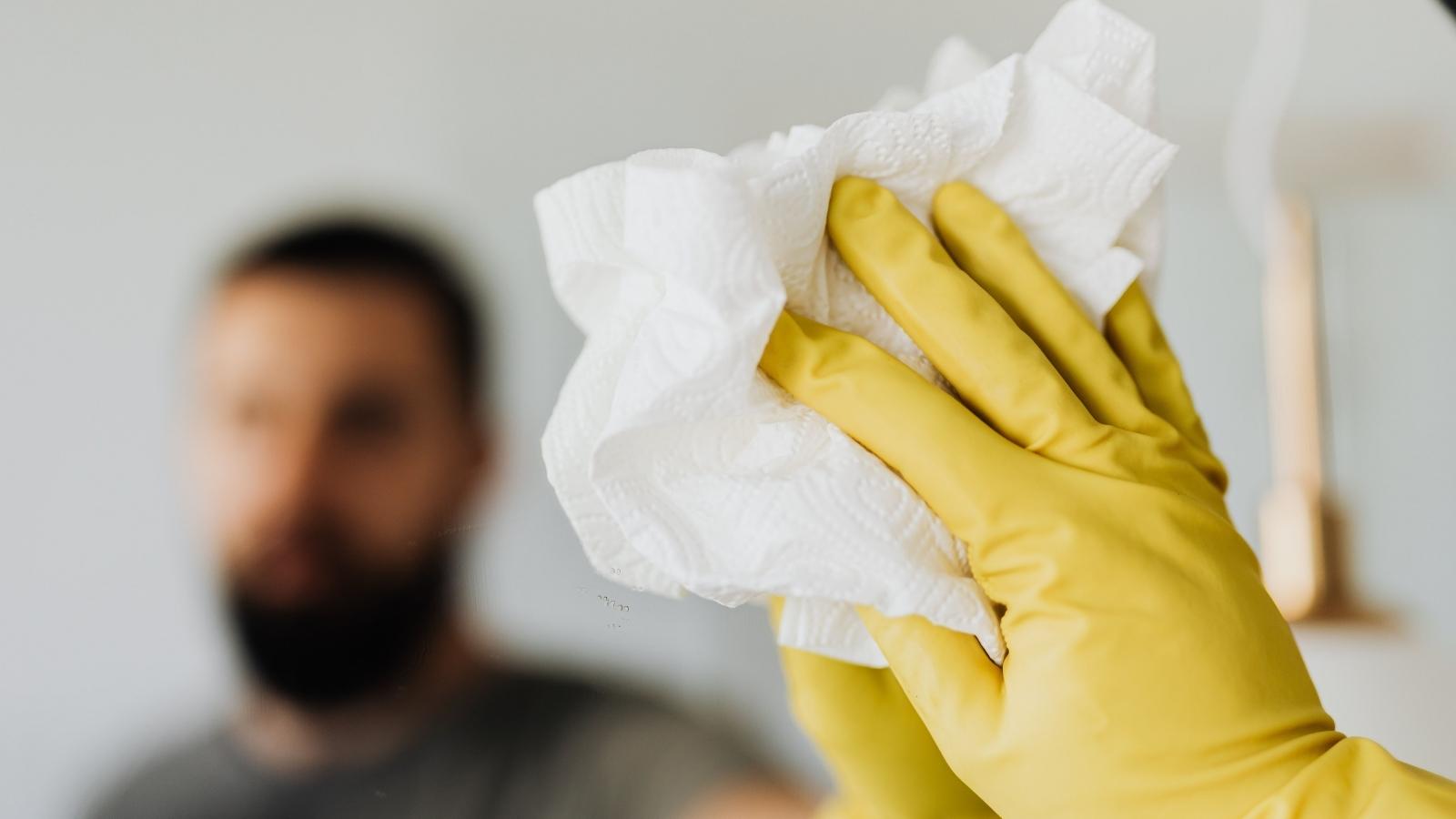 man cleaning in bright yellow gloves