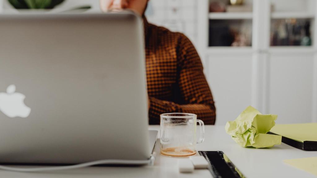 man in plaid shirt working at his laptop