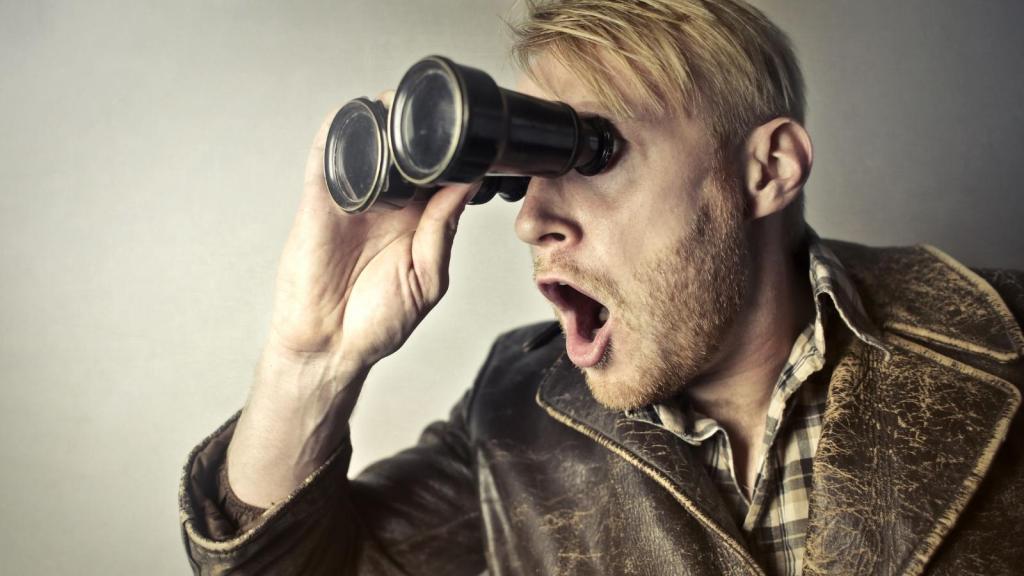 man looking through binoculars