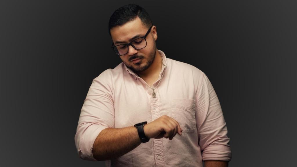 man with glasses looking at his watch