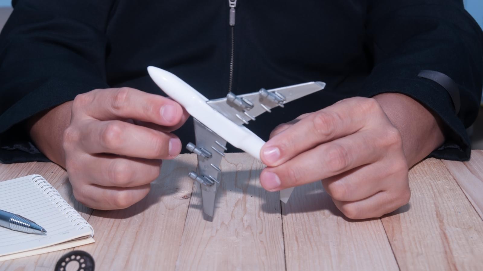 His Roommate Took Over the Living Room With Models—So He Made One Small Change That Drove Him Crazy man holding model airplane