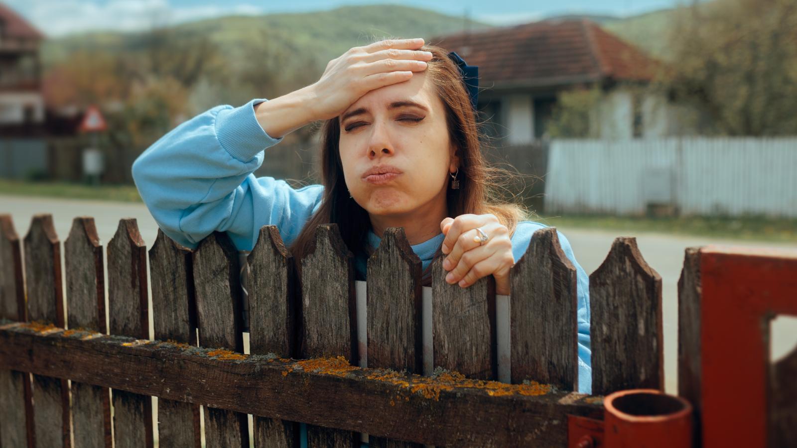 You’re Being Unreasonable: Neighborhood Parents Turn on Woman After She Complains About Broken Fence woman looking over a fence