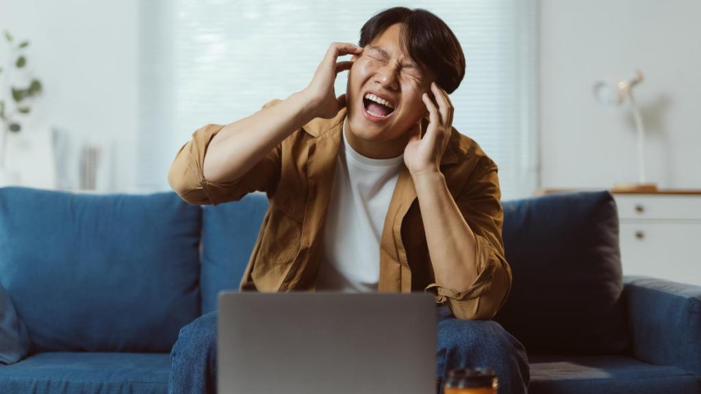 man plugging his ears